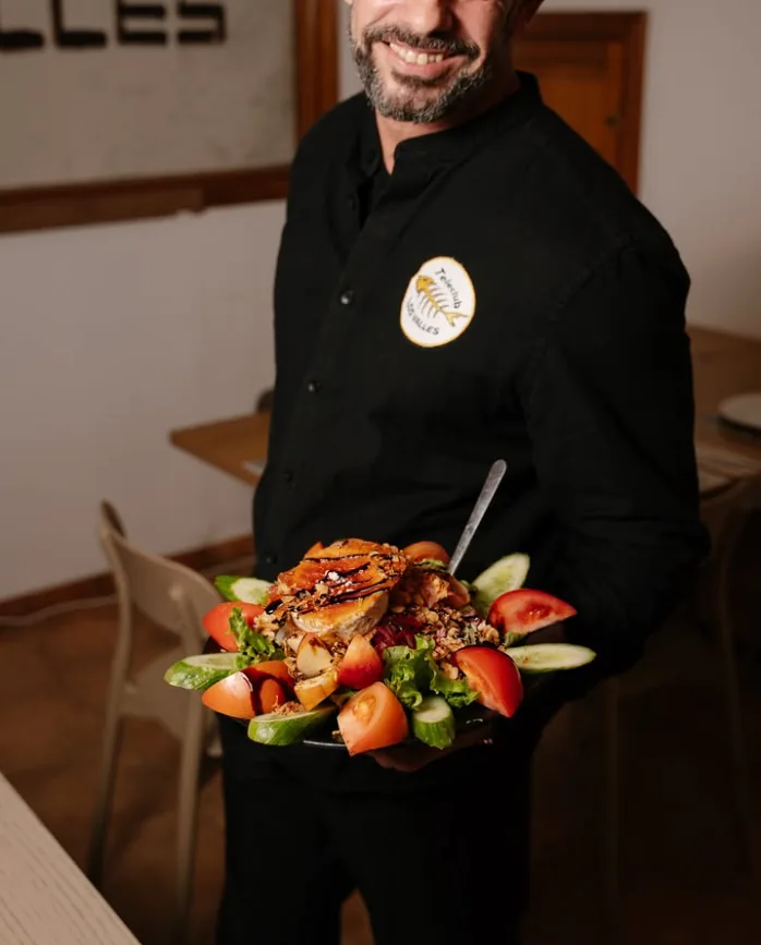 Miembro del equipo sirviendo una ensalada en sala