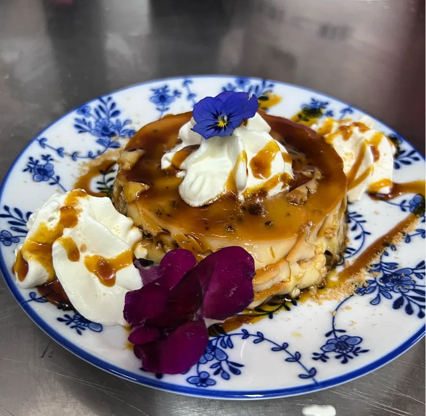 Flan casero con nata y flores comestibles