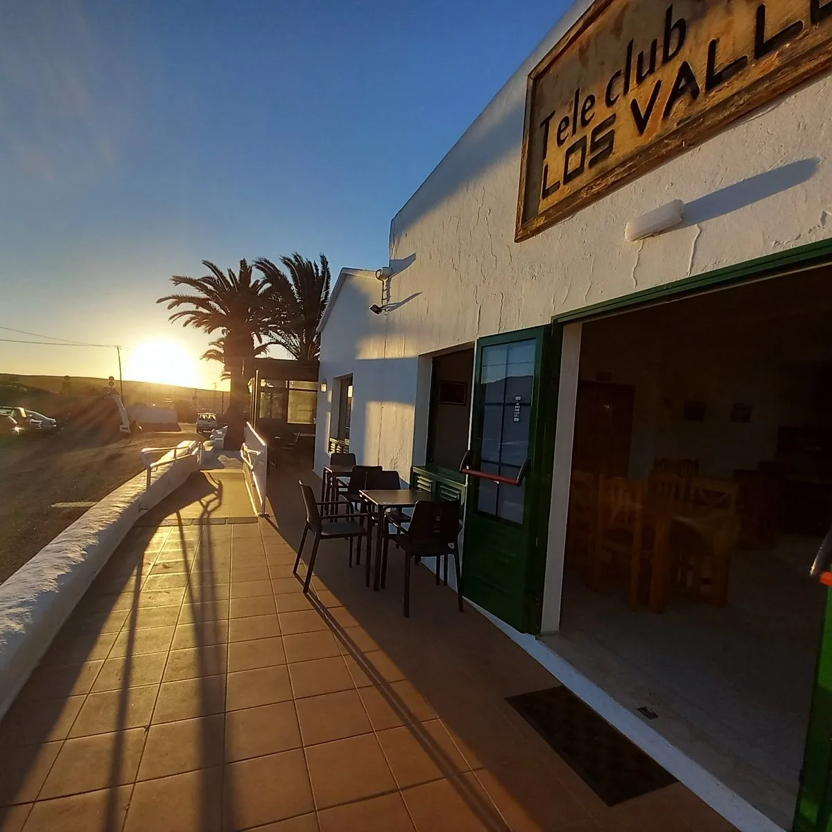 Terraza al atardecer con palmera y vistas al valle